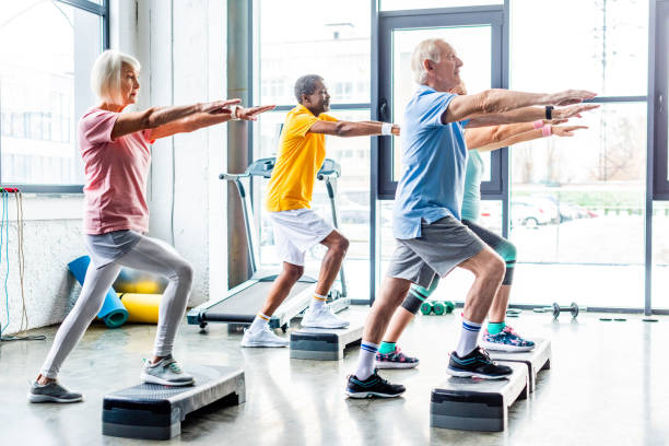 istock side view of multicultural senior athletes synchronous exercising on step platforms at gym 1088958492