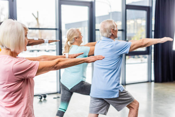 istock rear view of senior athletes synchronous doing exercise at gym 1088958510