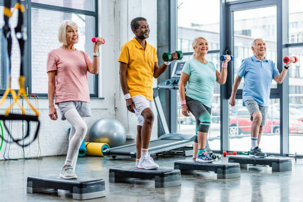 istock smiling senior multicultural sportspeople synchronous exercising with dumbbells on step platforms at gym 1088958586