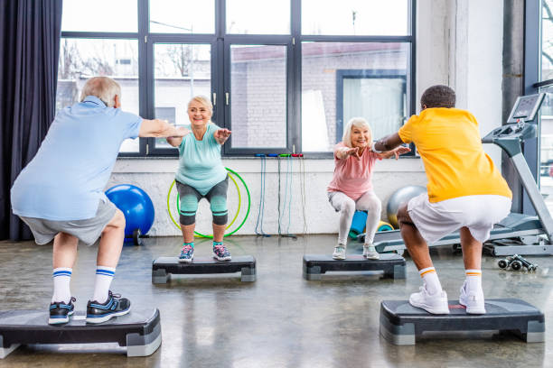 istock senior multiethnic sportspeople synchronous doing squats on step platforms at gym 1088958666