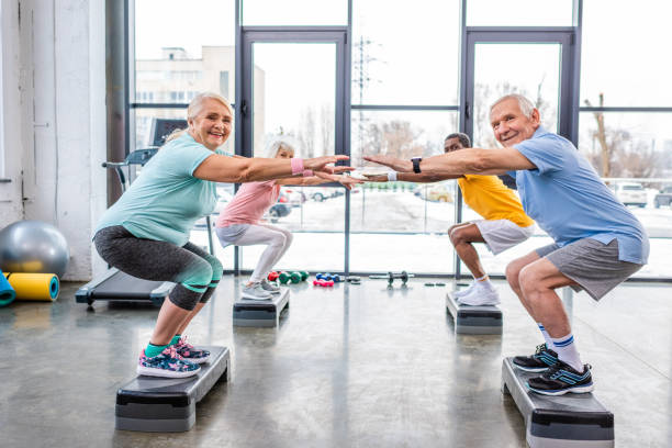 istock happy senior multiethnic sportspeople synchronous doing squats on step platforms at gym 1088958678