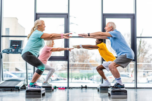istock side view of multicultural senior athletes synchronous doing squats on step platforms at gym 1088958682