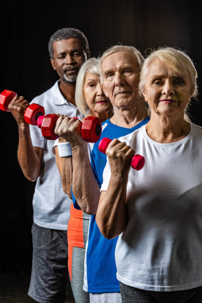 istock multicultural senior sportspeople exercising with dumbbells on black 1088960452