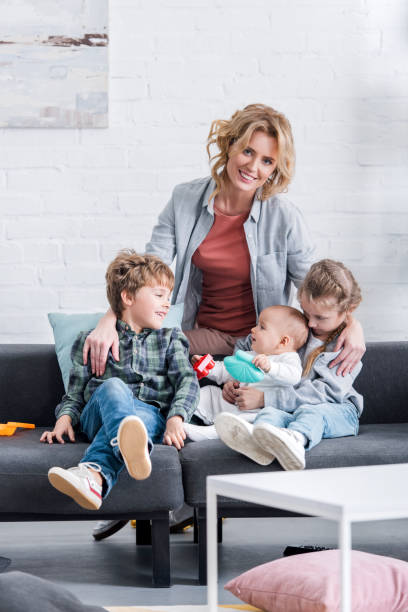 istock happy mother smiling at camera while spending time with three adorable children at home 1088961360