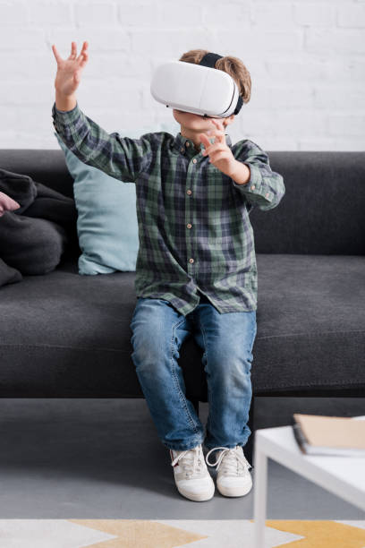istock child sitting on couch and using virtual reality headset at home 1088961470