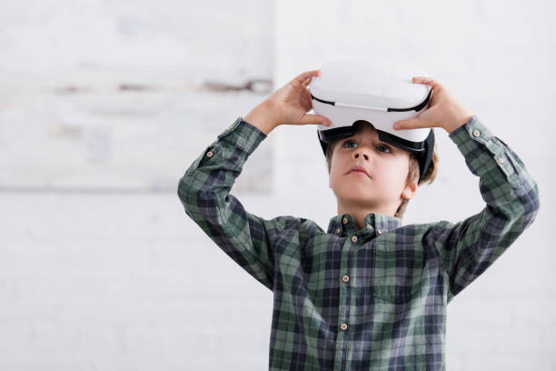 istock adorable boy using virtual reality headset and looking away at home 1088961484