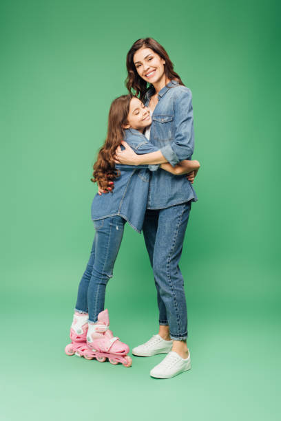 istock daughter in roller blades hugging mother on green background 1088963912