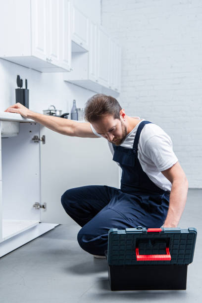 istock handsome adult repairman with toolbox checking sink in kitchen 1088965098