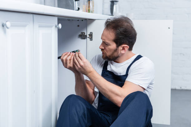 istock side view of handyman in working overall fixing wires from oven in kitchen 1088965108