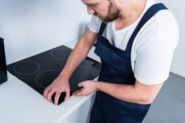 istock partial view of handyman in working overall fixing oven in kitchen 1088965120