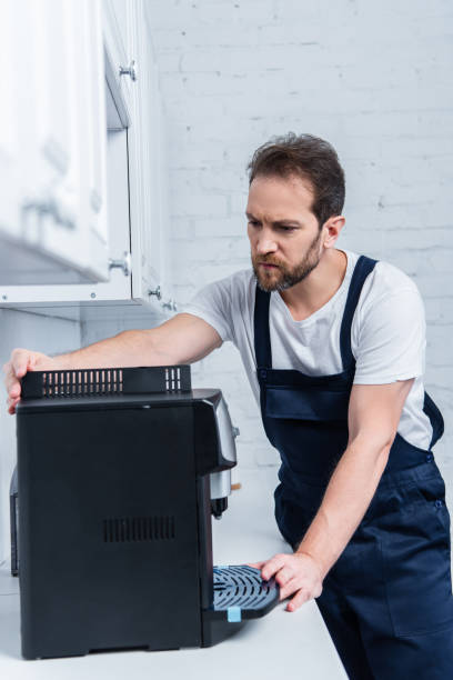 istock handyman in working overall repairing coffee machine in kitchen 1088965156