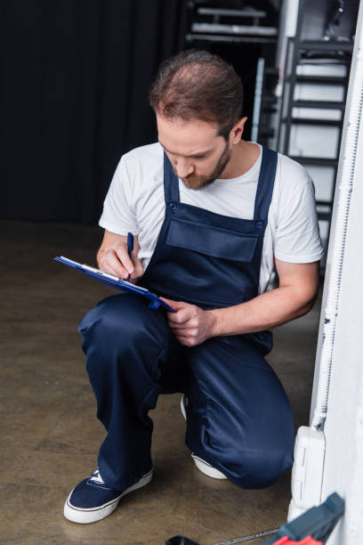 istock bearded male electrician writing in clipboard near plug socket 1088965648