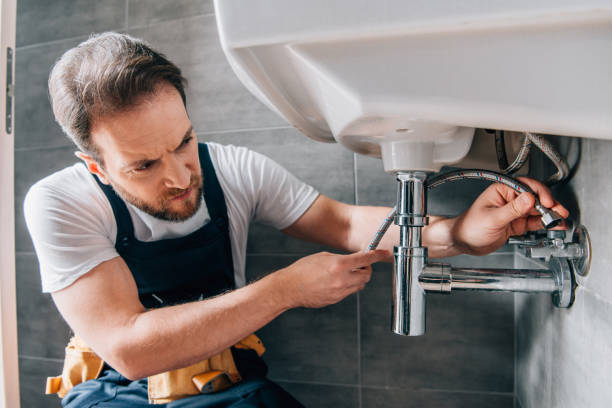 istock serious male plumber in working overall fixing sink in bathroom 1088965734