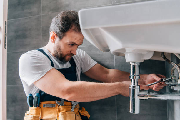 istock focused male plumber in working overall fixing sink in bathroom 1088965736