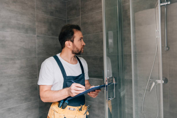 istock adult male plumber making notes in clipboard while checking shower in bathroom 1088965774