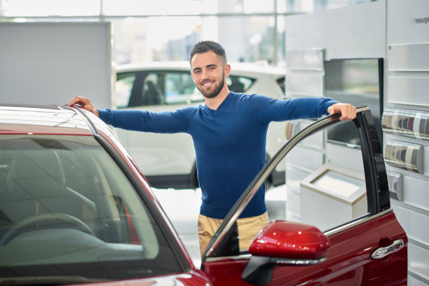 istock Young customer coming in car salon and choosing vehicle. 1088967162