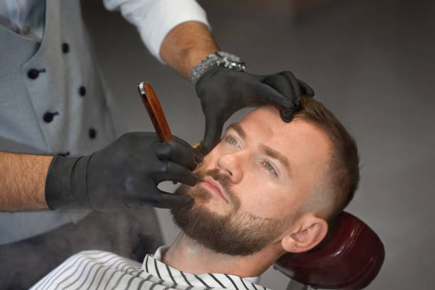 istock View from above of man on chair while barber shaving beard 1088967284