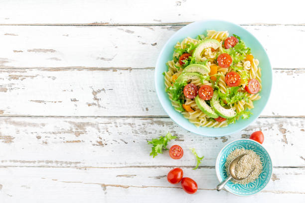 istock Pasta salad with avocado, fresh tomato, pepper and lettuce, top view 1088967398