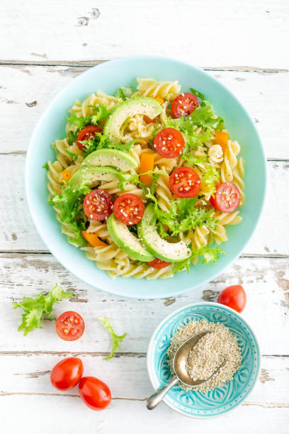 istock Pasta salad with avocado, fresh tomato, pepper and lettuce, top view 1088967420