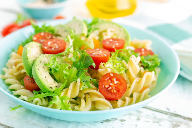 istock Pasta salad with avocado, fresh tomato, pepper and lettuce, top view 1088967508