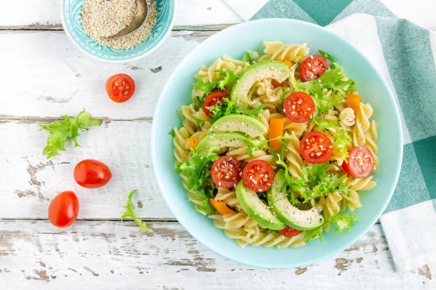 istock Pasta salad with avocado, fresh tomato, pepper and lettuce, top view 1088967570