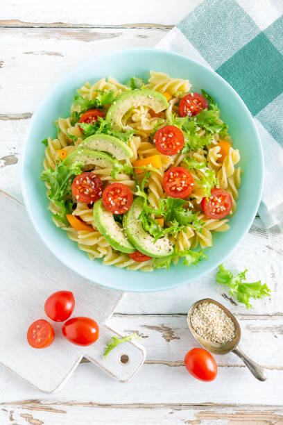 istock Pasta salad with avocado, fresh tomato, pepper and lettuce, top view 1088967584
