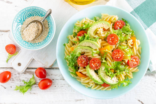 istock Pasta salad with avocado, fresh tomato, pepper and lettuce, top view 1088967618