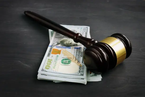 Photo of Gavel and money in the court. Penalty or bribe.