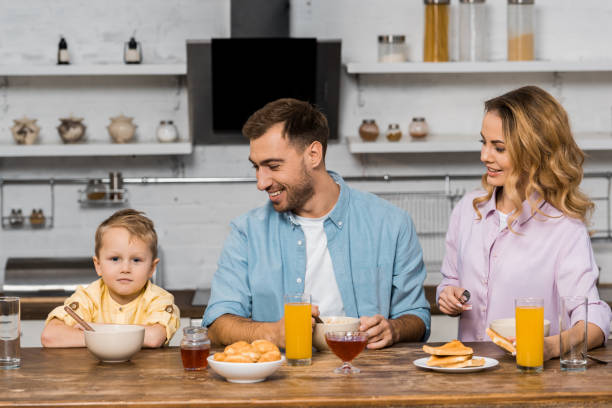 istock smiling parents looking at cute boy sitting at kitchen table 1088971230