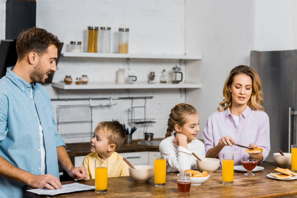 istock happy family having breakfast at table in kitchen 1088971348