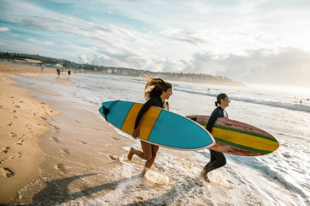 istock Two young women putting on wet suits for surfing 1088972808