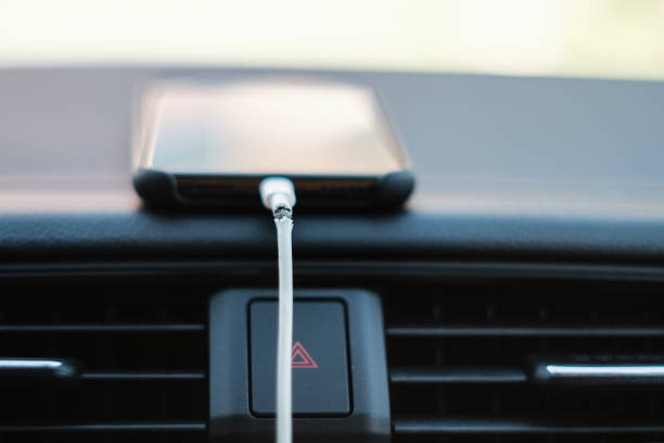 istock Broken Phone Charger Cable Connected to Smartphone on Car Dashboard 1088973352