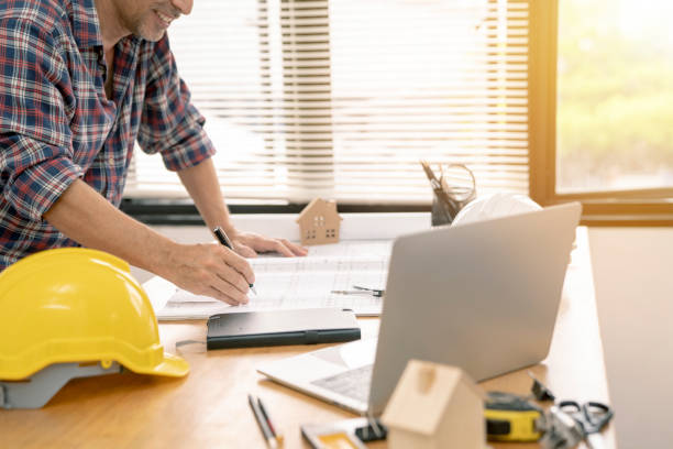 istock architect or civil engineer during drawing home or building in office on working table with office stationary , laptop ,color pallette sampling. 1088986440