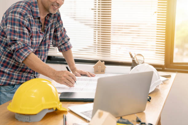 istock architect or civil engineer during drawing home or building in office on working table with office stationary , laptop ,color pallette sampling. 1088986554