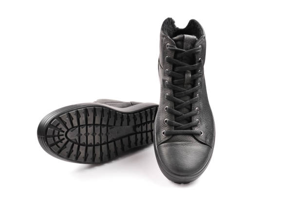 istock en's black leather shoes and a black camera on a black background. Copy space. 1088998628