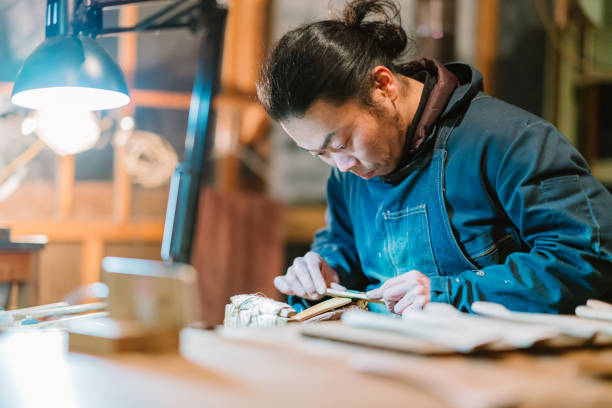 Asian man making craft from wood