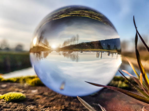 View of river at sunset through a lens ball - Canale Vacchelli - Spino d'Adda stock photo