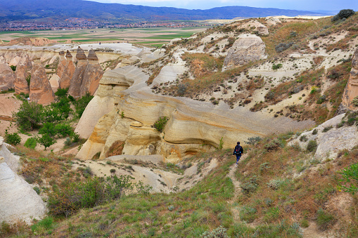Tired tourist returns home from a hike along the winding path of a mountain canyon in the rocky valleys of Cappadocia.