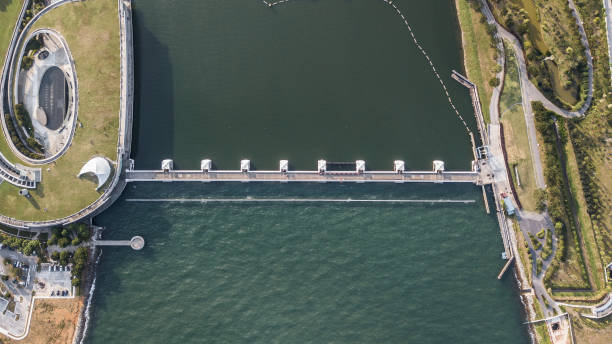 vista aérea da barragem em singapura. onde fesh vs salmoura de água / poupar água fresca / tecnologia da construção / emgineering design - weir - fotografias e filmes do acervo