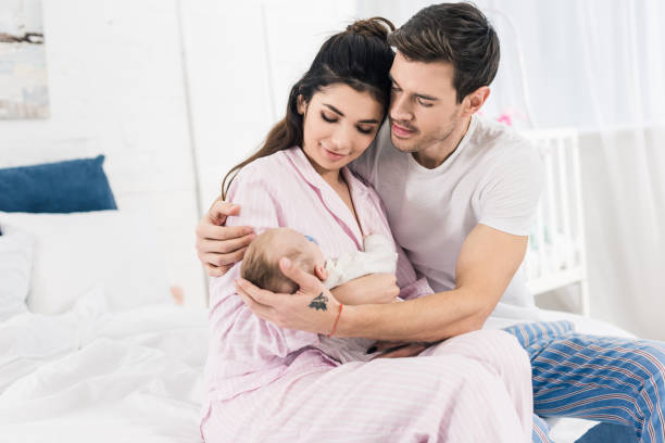 istock young man hugging wife with little son on hands at home 1089005462