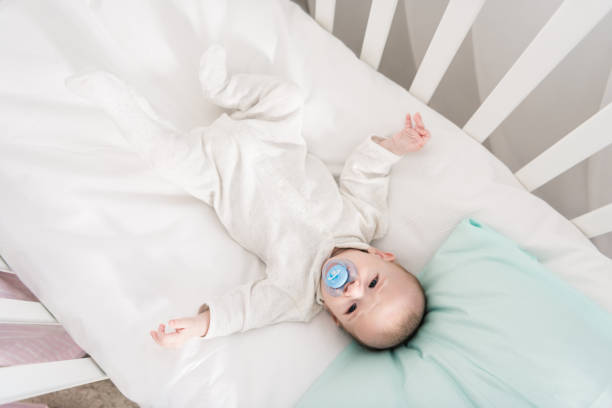 istock overhead view of little baby with pacifier lying in crib 1089005486