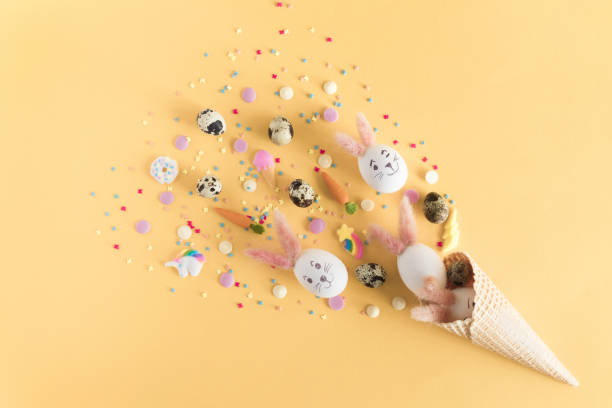 istock Happy Easter greeting card with copy space. Arrangement with colorful Easter eggs in waffle cone with place for text, isolated on pastel yellow background 1089007718