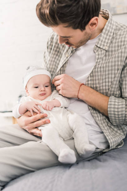 istock young man with baby boy in hands at home 1089013282