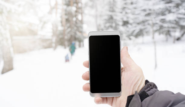 istock Phone in mens hand in winter snowy forest 1089018660