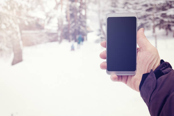 istock Phone in mens hand in winter snowy forest 1089018682