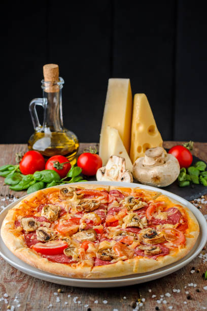 Pizza with ingredients on wooden background, close up
