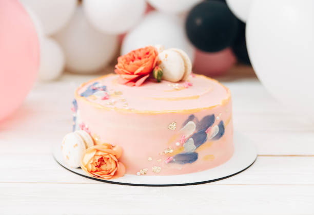 istock Birthday cake.Light pink with flowers and macaroon.Balloons background. 1089021574