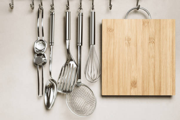 Close-up of kitchen items, wall on background Kitchen detail, utensils for cooking hanging with hooks on the wall utensil stock pictures, royalty-free photos & images