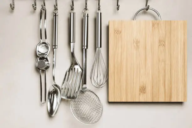 Kitchen detail, utensils for cooking hanging with hooks on the wall