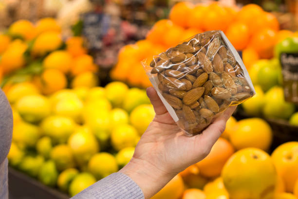 istock Female hand choosing almonds in the store 1089021960